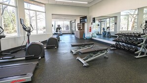 Ein Fitnessstudio mit Laufbändern, Crosstrainern und Kurzhanteln.