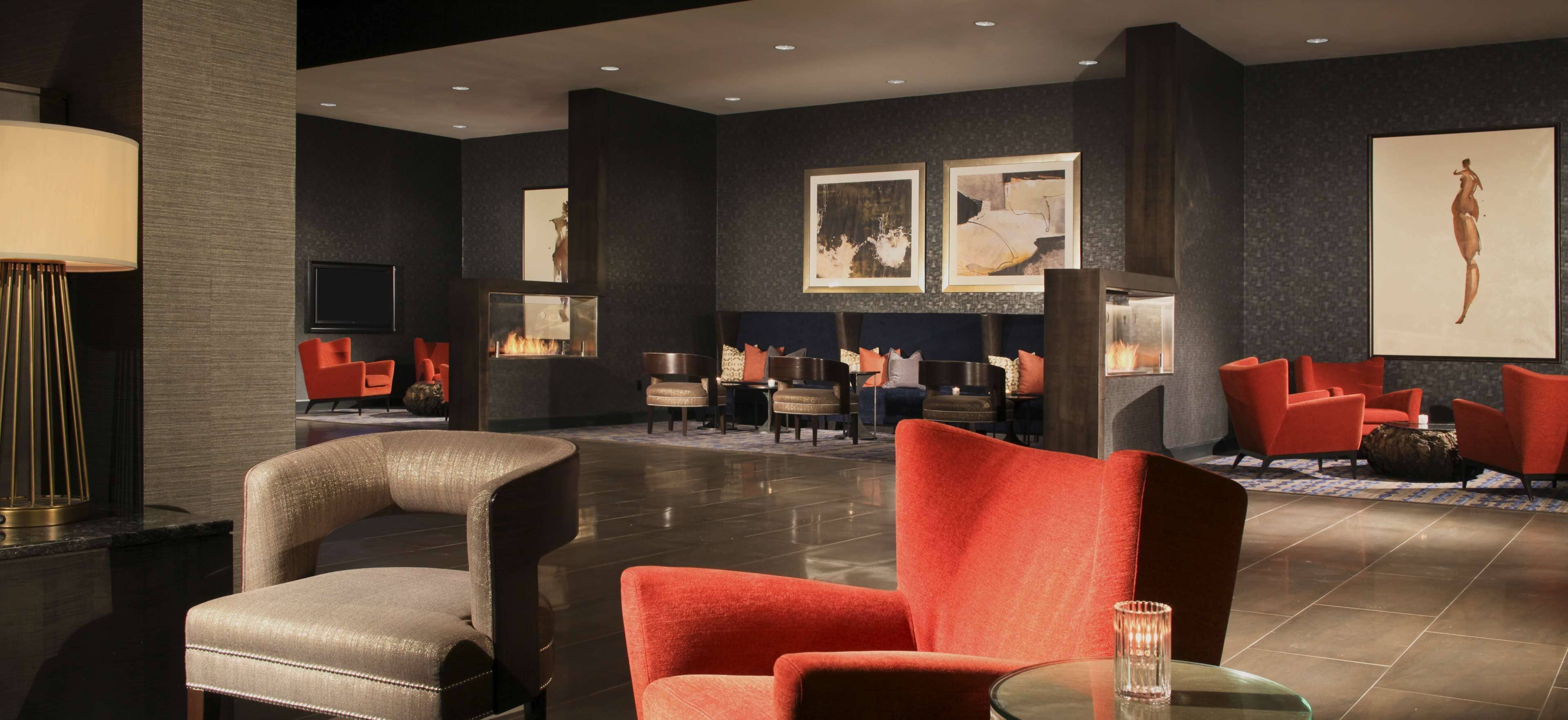 A modern lobby with a fireplace, seating area, and artwork on the walls.