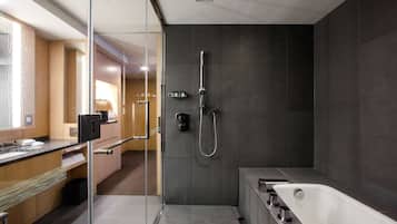 A modern bathroom with a glass-enclosed shower, a bathtub, and a vanity with a mirror.