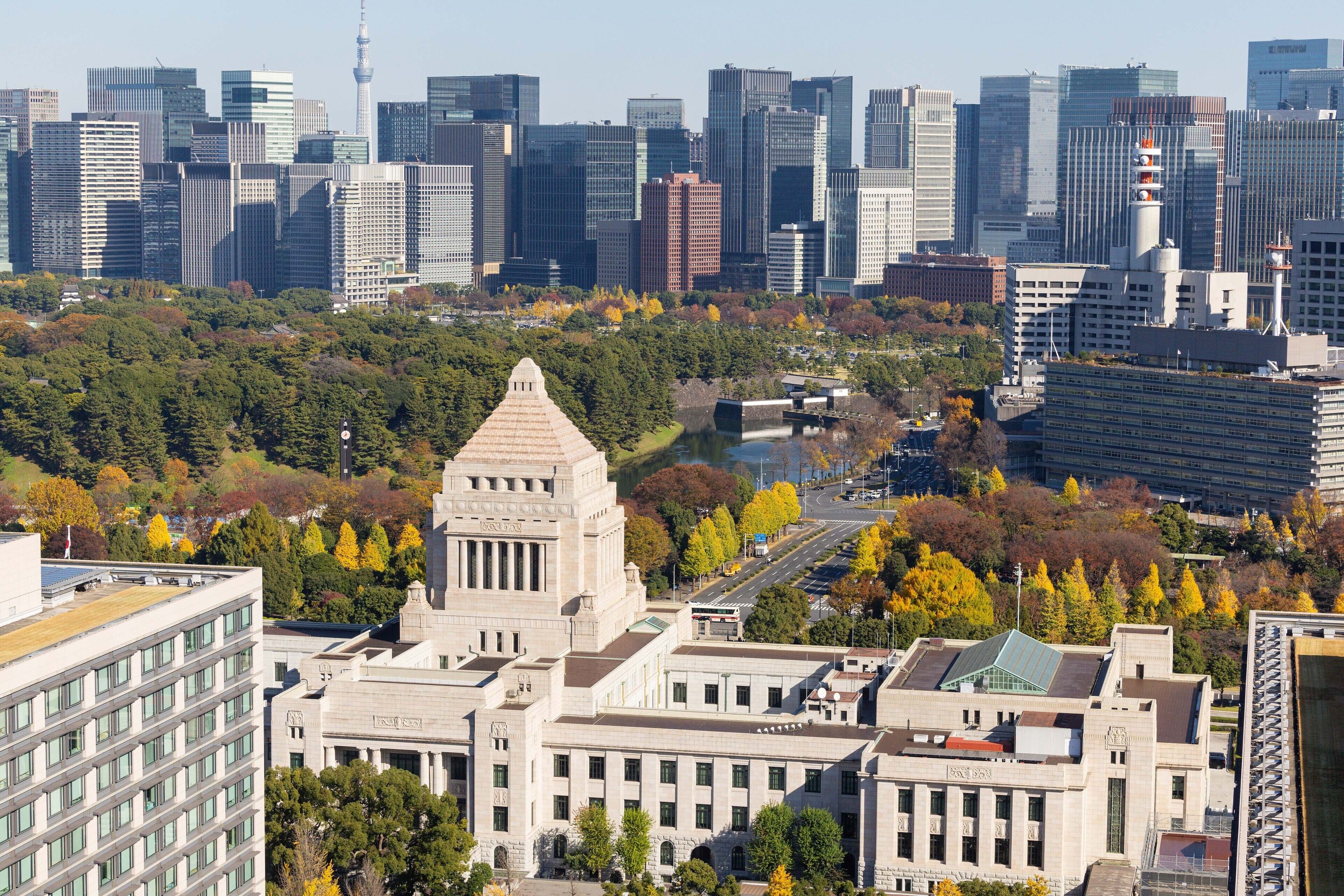 A cityscape with a prominent historic building surrounded by modern skyscrapers.