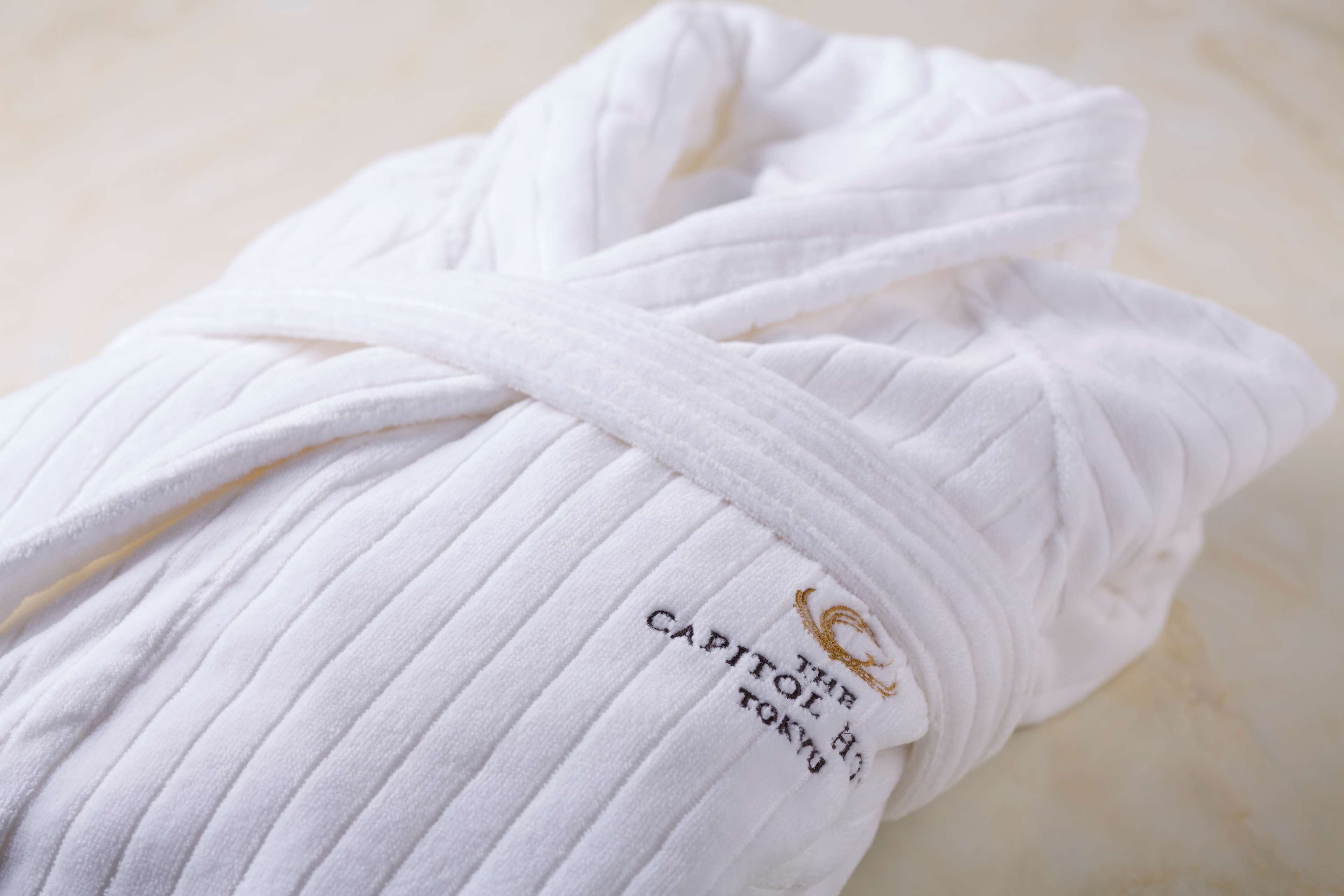 A white towel with a label that reads 'CAPITOL HOTEL TOKYO'.