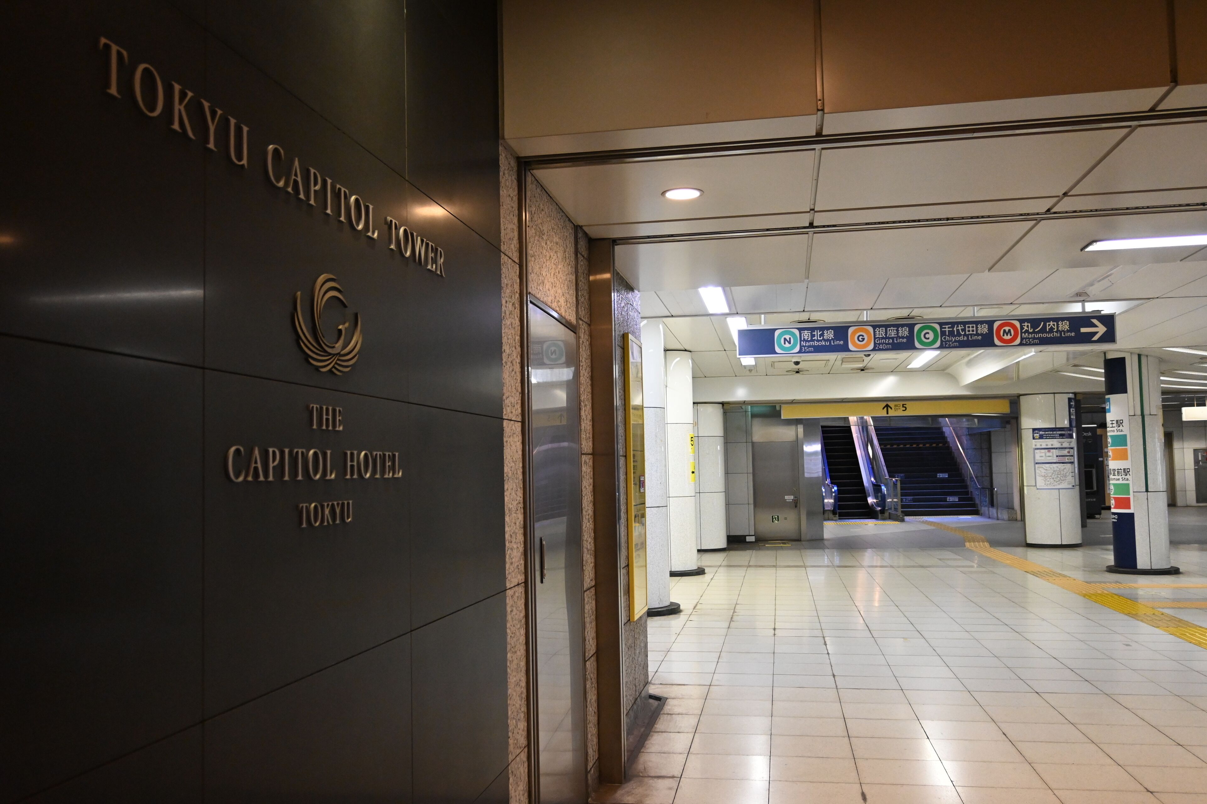 A subway station entrance with signs for Tokyo Metro lines and a hotel entrance.