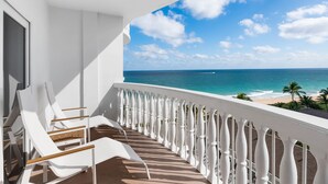 A balcony with white railings and white lounge chairs, overlooking a beach and ocean. - Beachcomber Resort & Club (Pompano Beach)