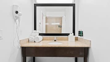 A bathroom with a sink, mirror, towel rack, and hair dryer.