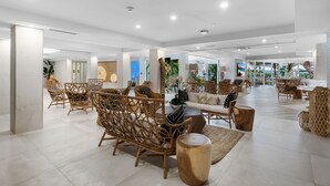 A spacious, well-lit lobby with wicker furniture, a central seating area, and a view of the outdoors. - Beachcomber Resort & Club (Pompano Beach)