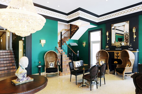 A room with a chandelier, a staircase, and a large mirror. - Cavalier Hotel South Beach (Miami Beach)