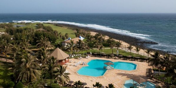 Relax by the pool or on the beach, surrounded by palm trees and ocean views.