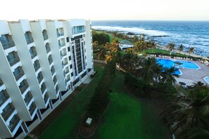 Enjoy ocean views from the hotel's spacious balconies, overlooking a pool area with lounge chairs and a cabana.