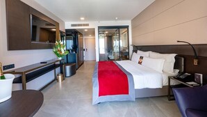 Una habitación de hotel moderna con cama, mesita de noche y un escritorio con silla.