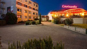 A hotel with a courtyard, a restaurant named Courtepaille, and a sign for the Bordeaux Le Lac Grill. - ibis Bordeaux Lac (Bordeaux)
