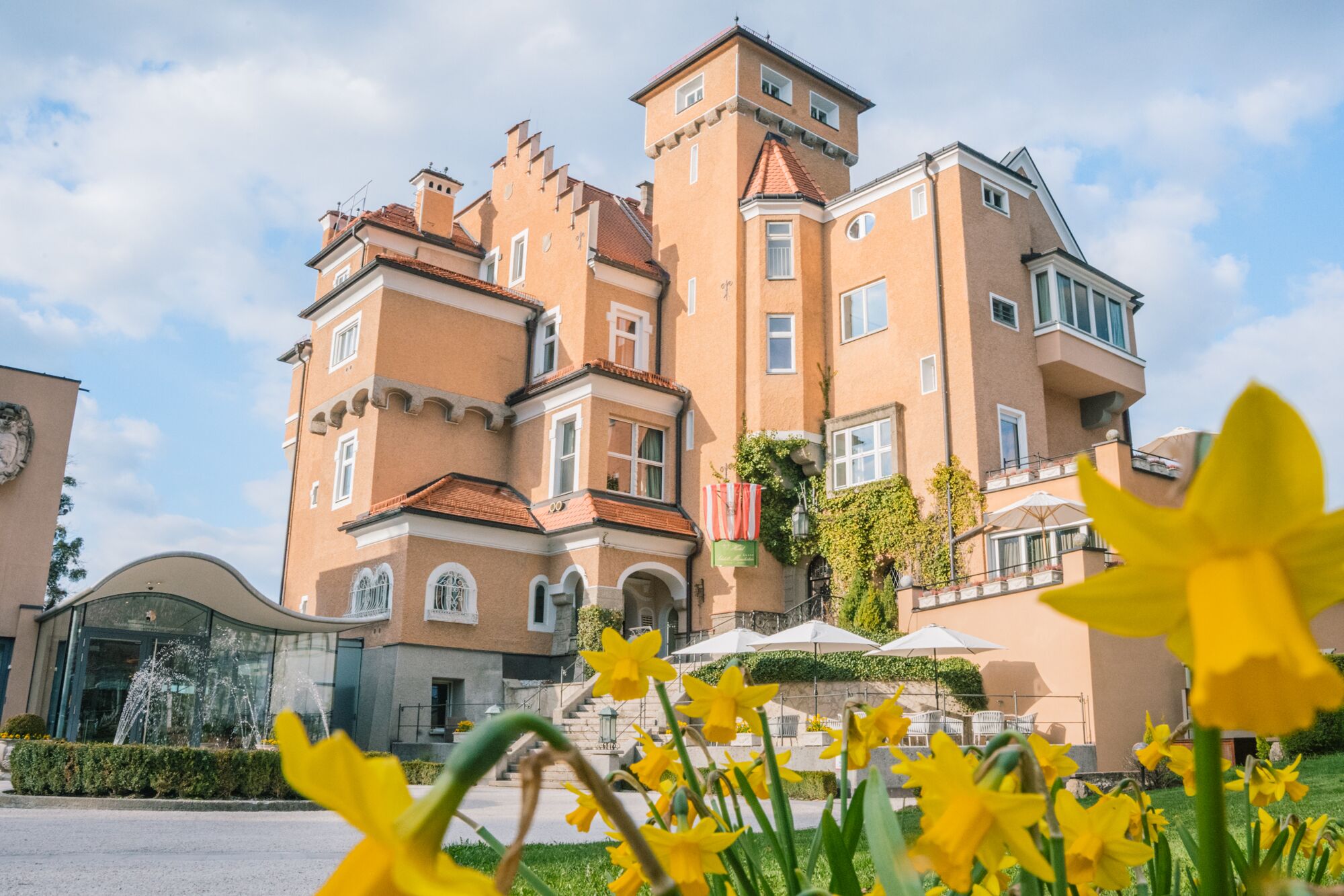A large, multi-story building with a turret and a balcony.