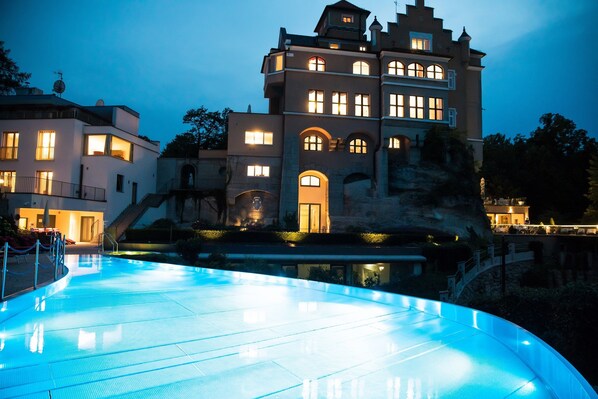 Un edificio grande de varios pisos con una piscina al frente.