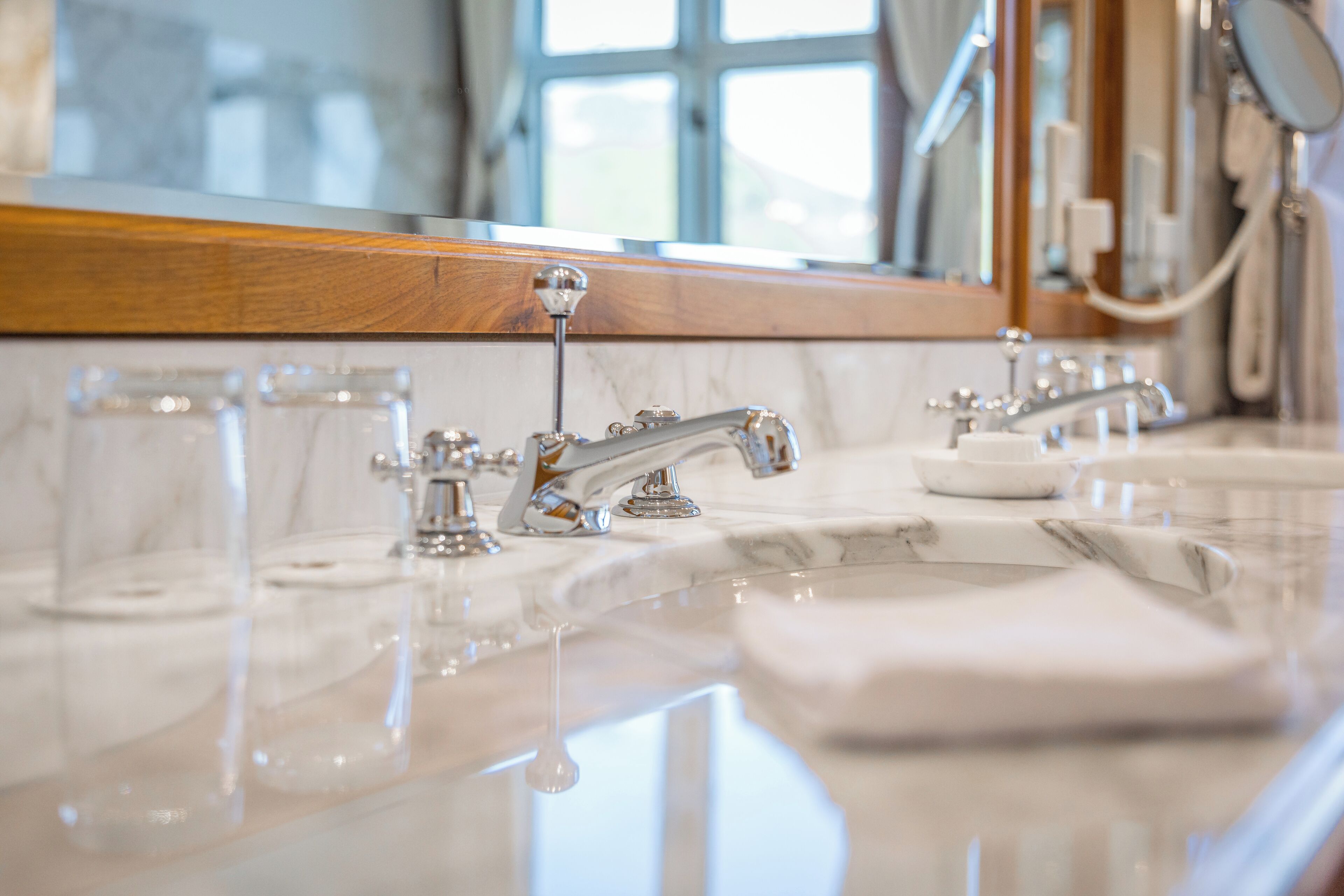 A bathroom with two sinks, a mirror, and a window.
