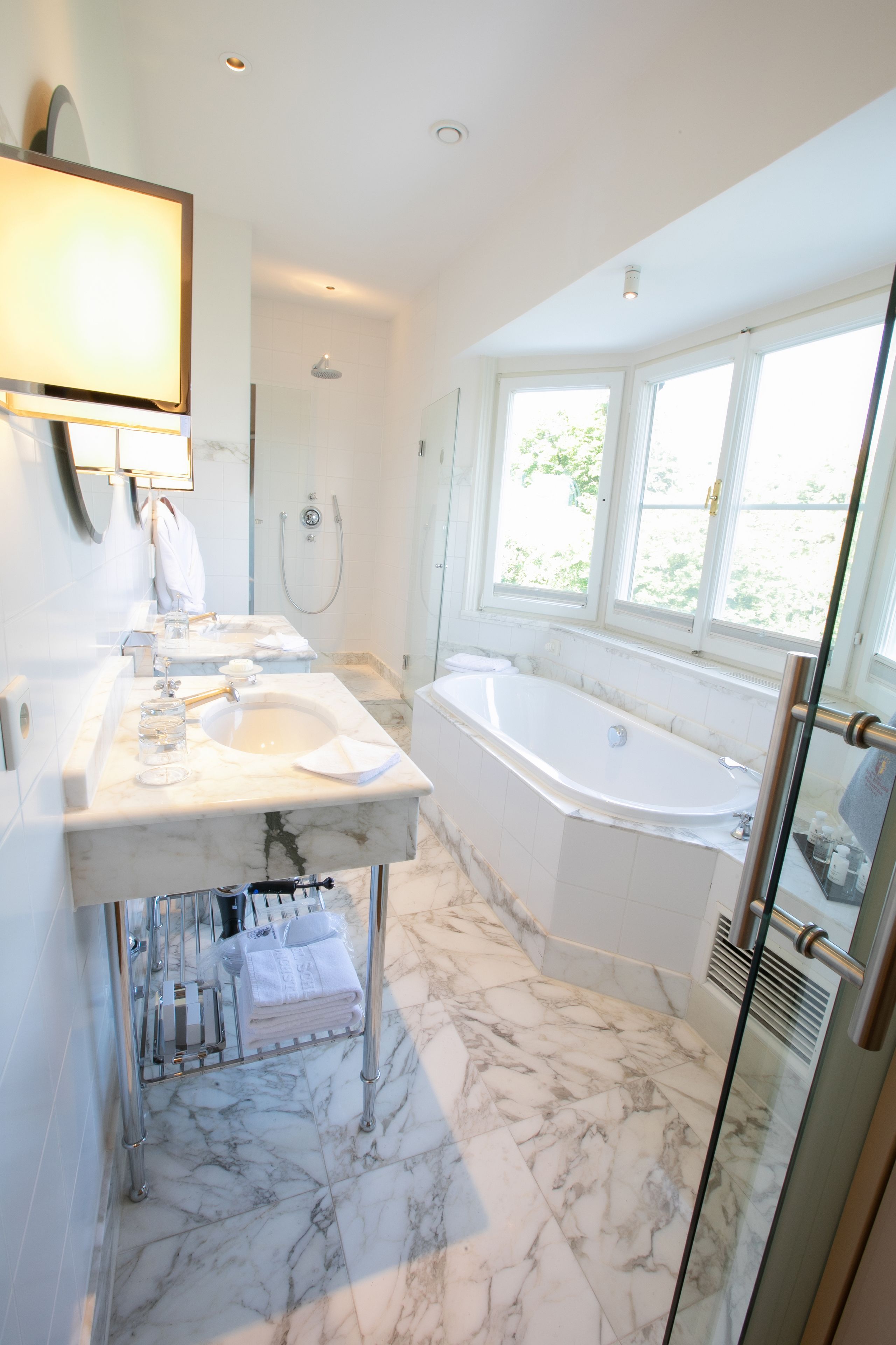 Une salle de bain moderne dotée d’une grande baignoire, d’une douche séparée et d’un meuble-lavabo avec un miroir.