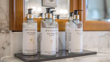 Three bottles of BVLGARI Eau de Parfum on a marble countertop.