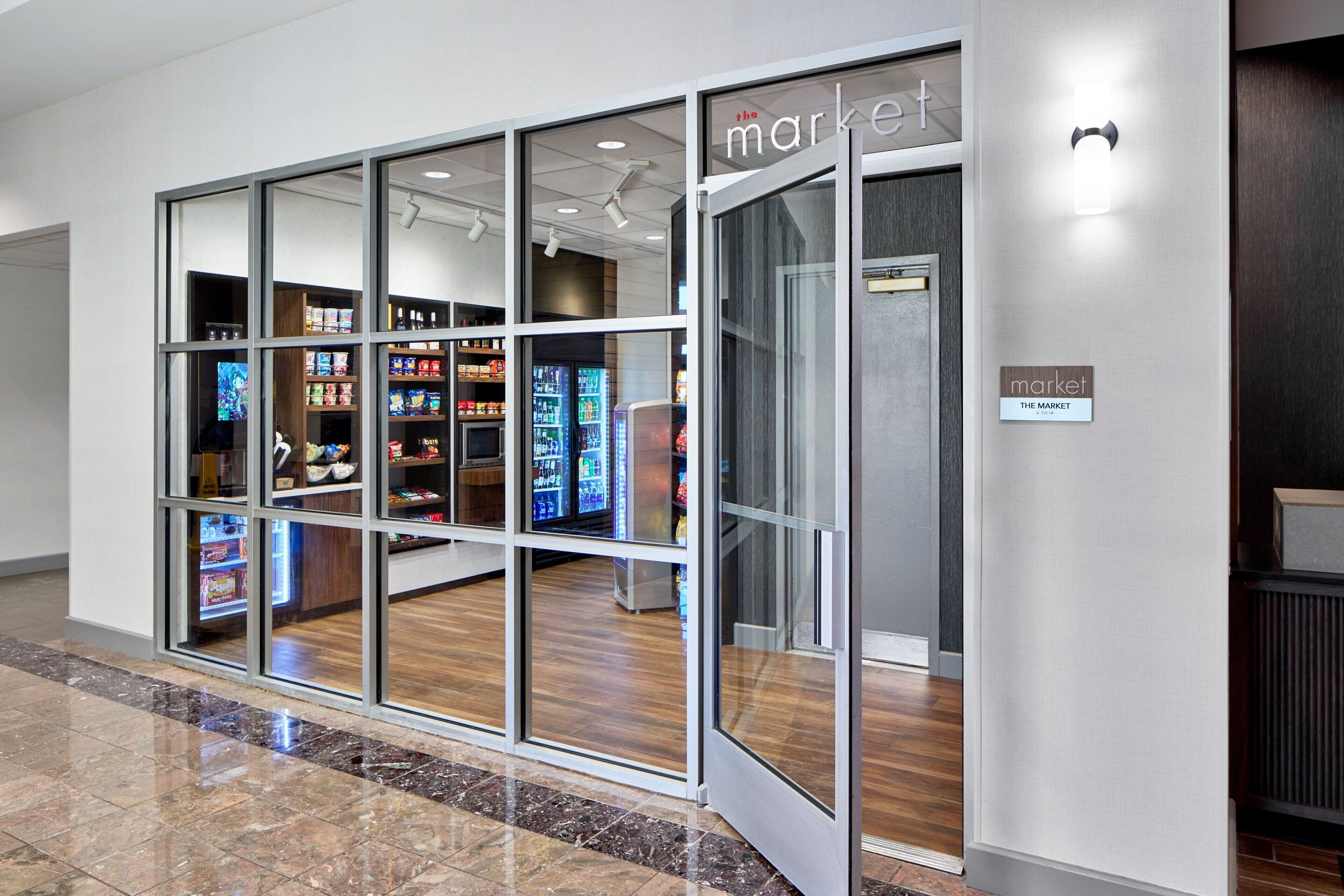 A modern market with glass storefronts and a clean, tiled floor.