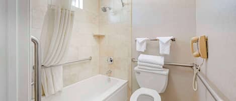 A modern bathroom with a bathtub, toilet, and shower.