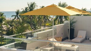 A rooftop terrace with a glass balustrade, a yellow umbrella, and a view of the beach and palm trees. - Leslie Hotel Ocean Drive (Miami Beach)