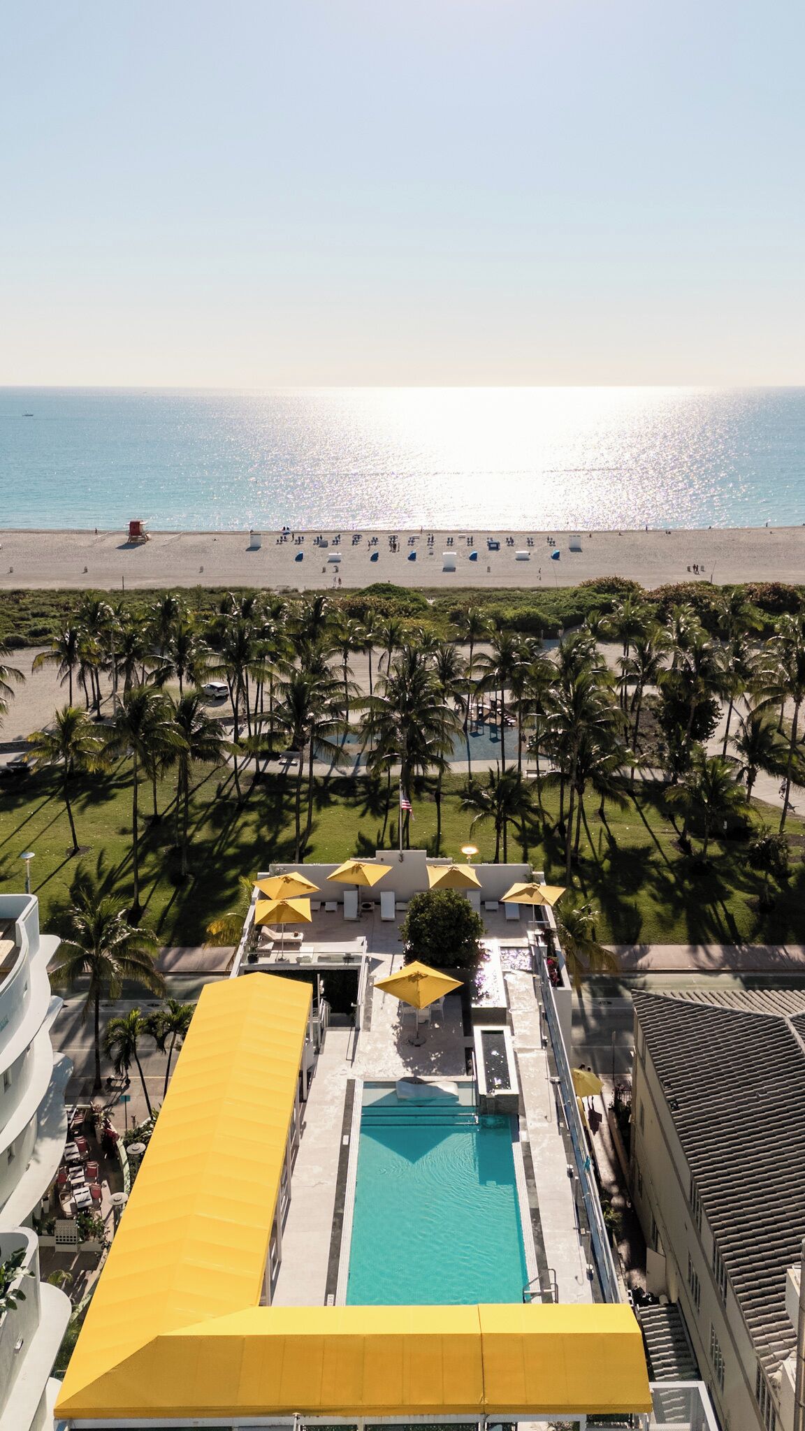 Un resort con piscina, spiaggia e palme.