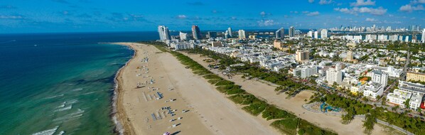 Na praia, espreguiçadeiras, toalhas de praia 