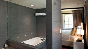 A modern bathroom with a bathtub, a large mirror, and a separate shower area. - Leslie Hotel Ocean Drive (Miami Beach)
