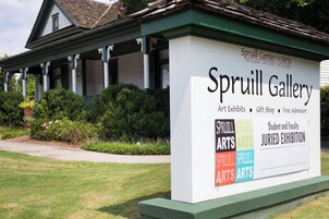 A sign for Spruill Gallery with text about art exhibits, gift shop, and free admission.