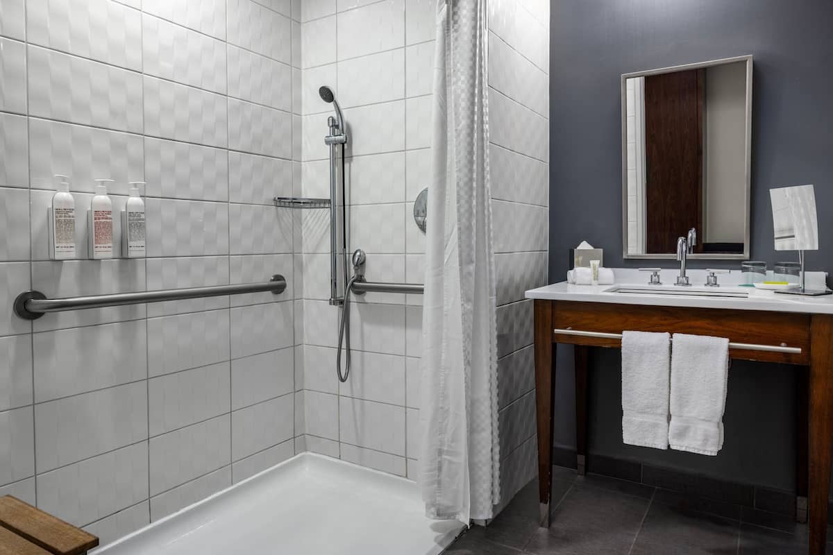 A modern bathroom with a shower, toilet, and sink.