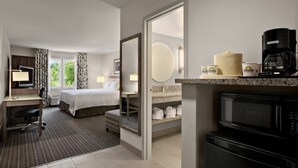 Une chambre d’hôtel avec un lit, un bureau et une kitchenette.