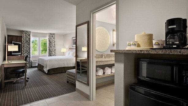 A hotel room with a bed, desk, and kitchenette. - Comfort Inn Williamsburg Gateway (Williamsburg)