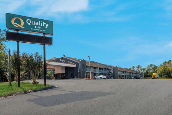 Un hôtel Quality Inn, appartenant au groupe Choice Hotels, avec une grande enseigne, un parking et un bâtiment à plusieurs étages doté d’une architecture moderne.