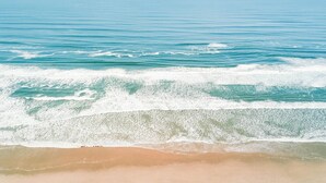 A beach with waves approaching the shore.