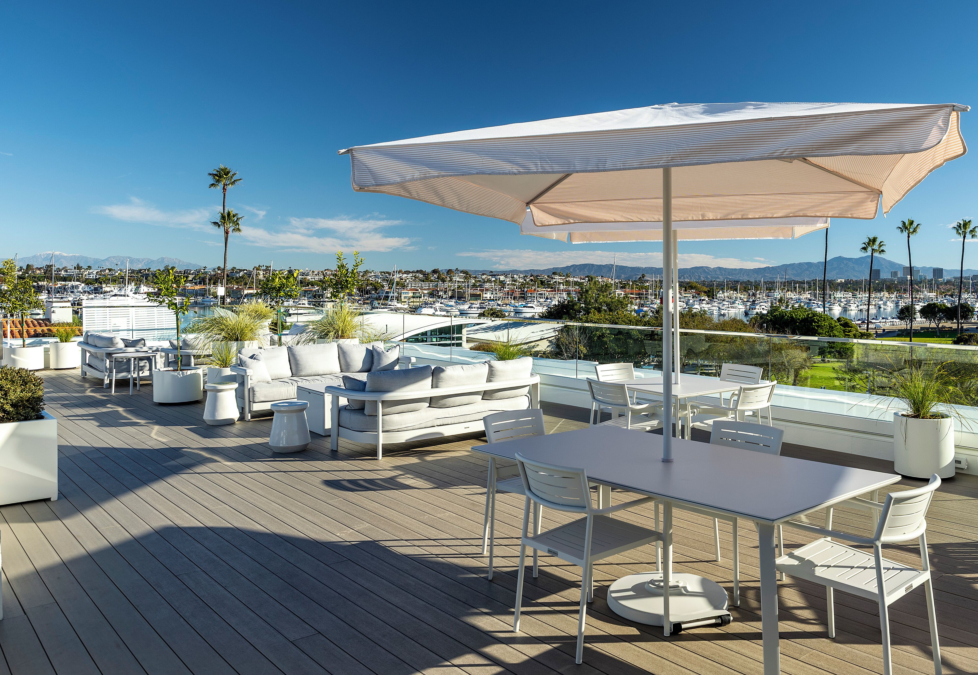 Terraza en la azotea con asientos al aire libre, una mesa y un gran paraguas.
