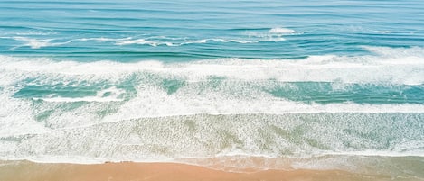 Pantai di sekitar, payung pantai, dan handuk pantai