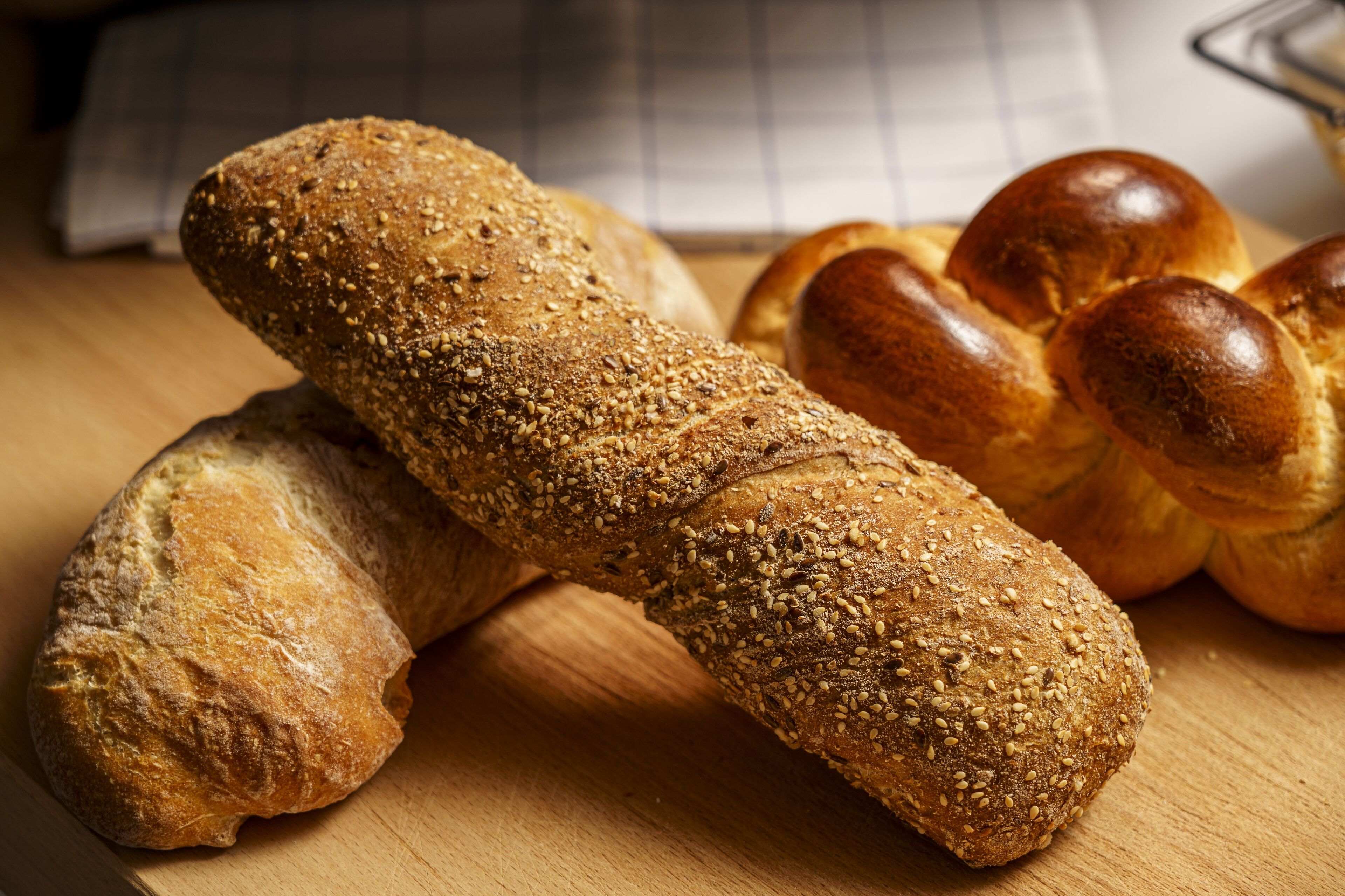 A loaf of bread with sesame seeds on a wooden surface.