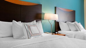 A hotel room with two beds, a nightstand, a lamp, and a wall with a geometric design. - Country Inn & Suites by Radisson, Bismarck-Mandan (Bismarck)