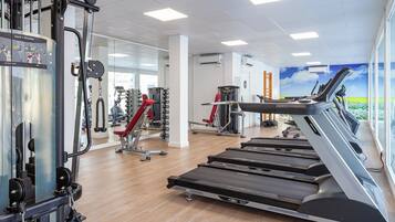 A gym with treadmills, weight machines, and mirrors.