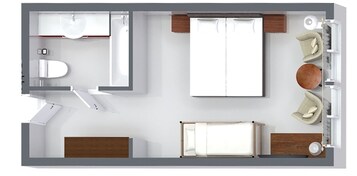 Distribución de una habitación de hotel con cama, escritorio, silla, sofá, mesita y baño.