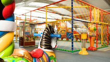 A carousel with colorful horses and a netted enclosure in the background.