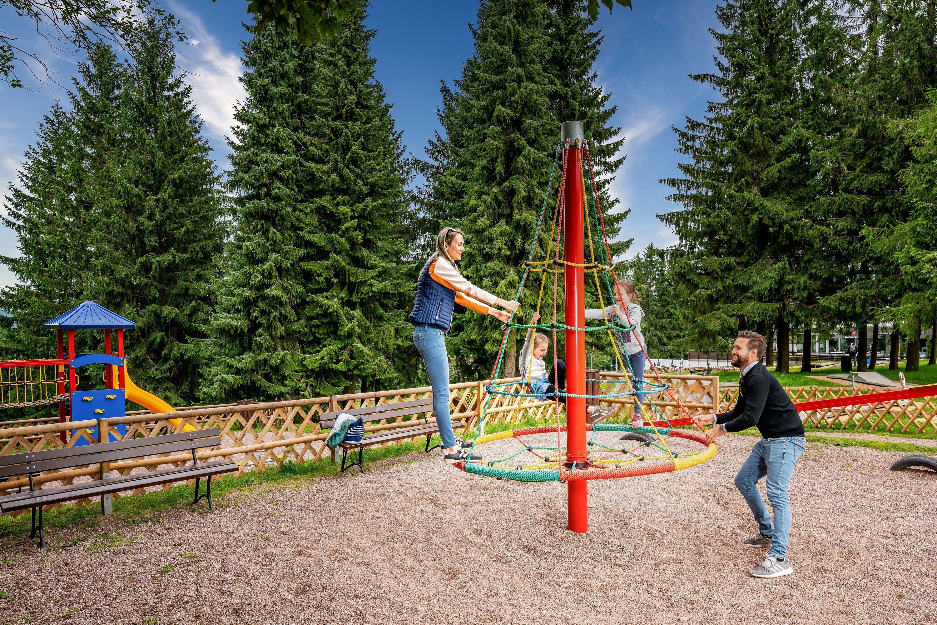 A playground with a swing set, a slide, and a climbing structure.