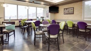 A modern restaurant with a brick wall, large windows, and a flat-screen TV. - Drury Inn & Suites San Antonio Northeast (San Antonio)