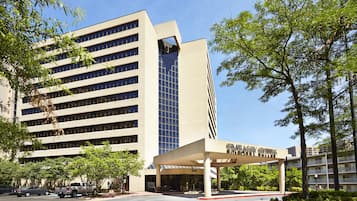 A modern building with a covered entrance labeled 'Embassy Suites.'