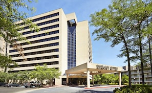 Un edificio moderno con entrada cubierta que dice 'Embassy Suites'.