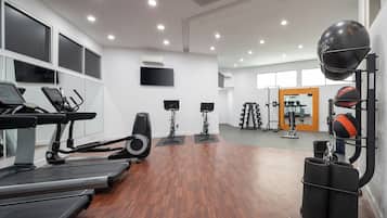 A gym with treadmills, stationary bikes, and weightlifting equipment.