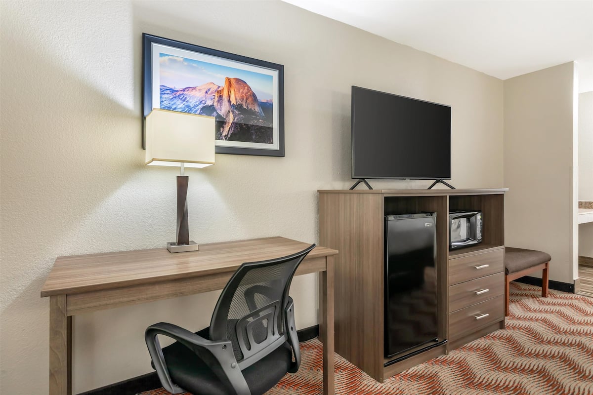 Escritorio, cortinas blackout y tabla de planchar con plancha