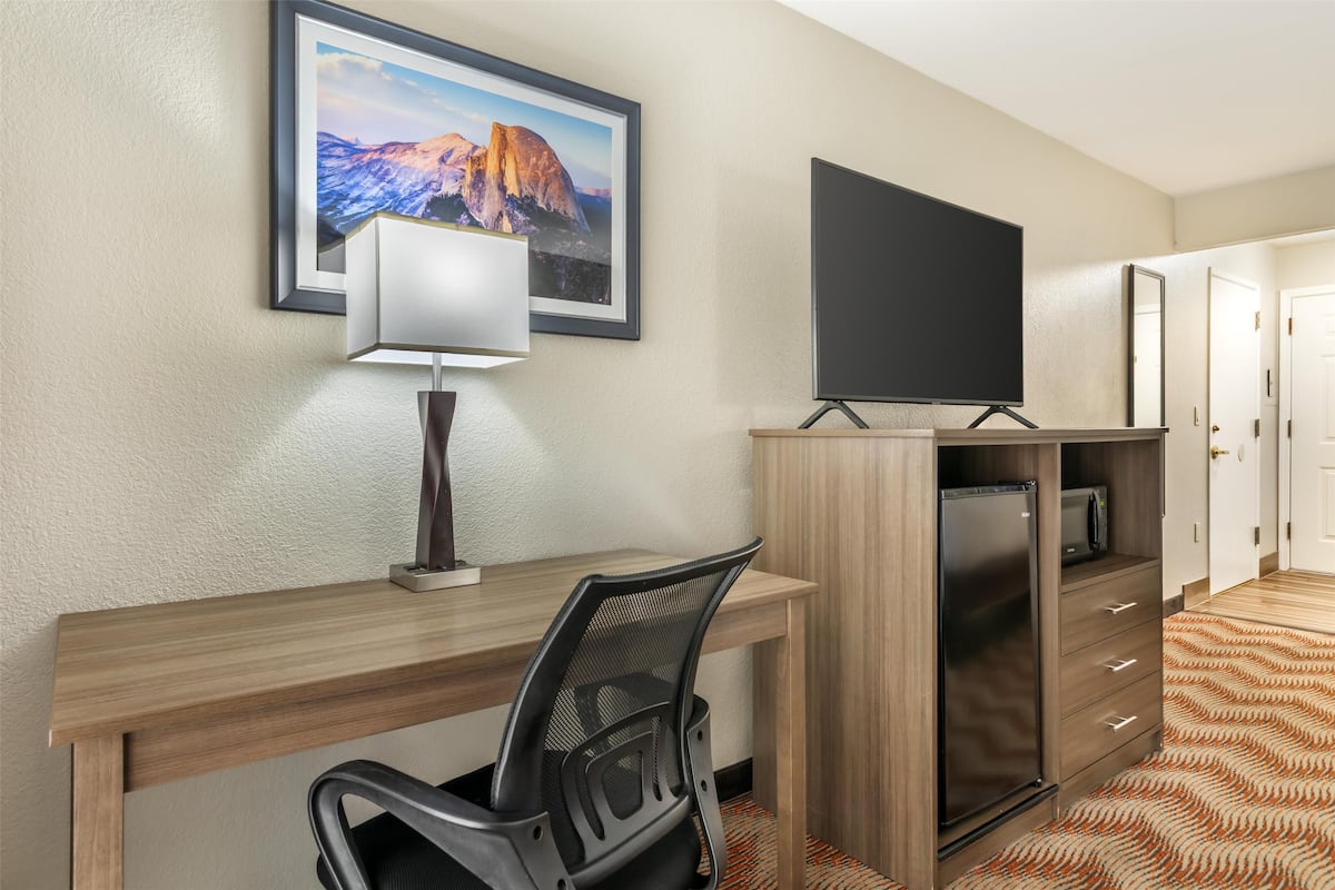 Escritorio, cortinas blackout y tabla de planchar con plancha