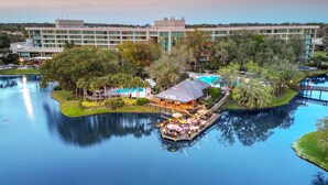 A riverside restaurant with outdoor seating, a dock, and a large hotel building in the background. - Sawgrass Marriott Golf Resort & Spa (Ponte Vedra Beach)