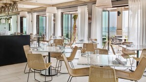 A spacious dining area with high ceilings and large windows, offering views of the sea. - Sawgrass Marriott Golf Resort & Spa (Ponte Vedra Beach)