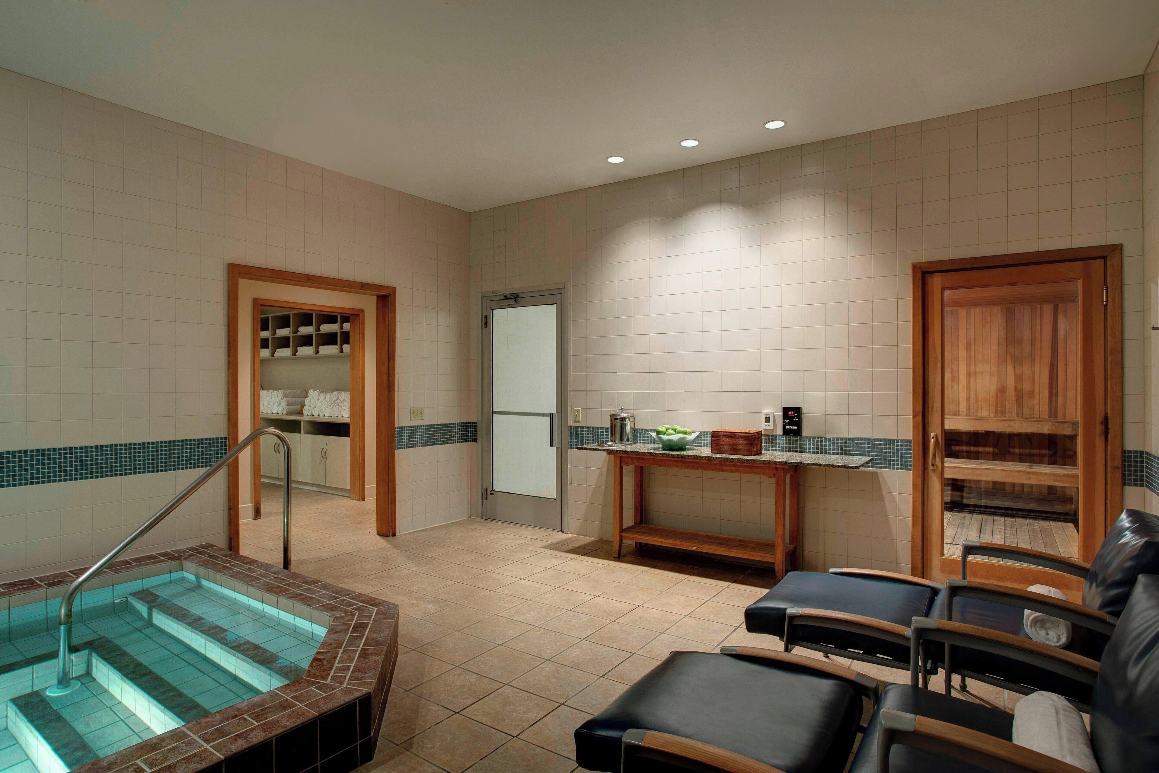 A spa area with a hot tub, seating, and a small reception desk.