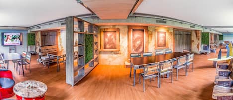 A modern conference room with a long table, chairs, and a television screen.