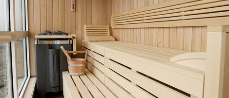 A sauna with wooden benches and a heater.